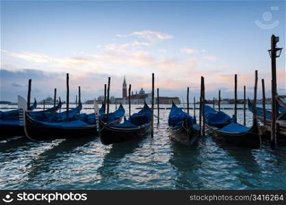 Early morning over the Venice Grand Canal. Early morning over the Venice Grand Canal. Famous Venice gondolas at the foreground, Church of San Giorgio Maggiore at the background.