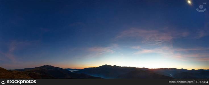 Early predawn in mountains. Autumn night panorama with stars and moon in sky