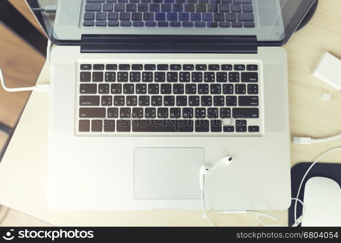 earphone and laptop computer notebook on wooden table, vintage tone