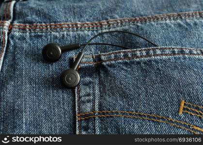 Earphones in a back pocket of a jean