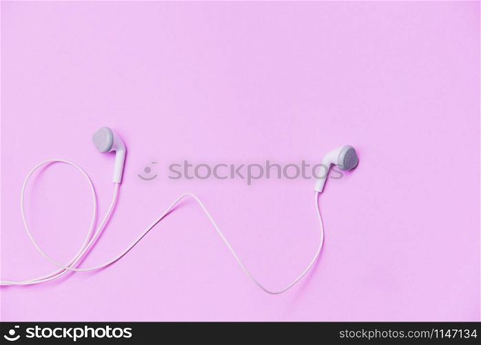 Earphons on pink background / Music is my life and Entertainment listen to music concept with white earphones on top view