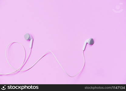 Earphons on pink background / Music is my life and Entertainment listen to music concept with white earphones on top view