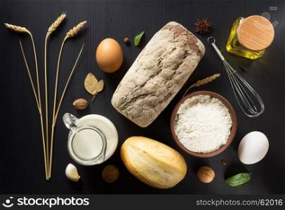 ears of wheat and bakery ingredient on wooden background