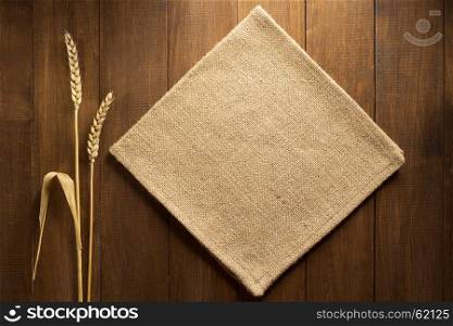 ears of wheat and cloth on wooden background
