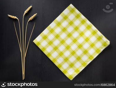 ears of wheat and cloth on wooden background