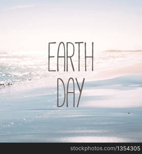 Earth Day concept on seashore background. Summer sand beach and seashore waves defocused blurred square shot