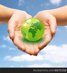 earth day, people, ecology and environment concept - close up of female hands holding green globe over blue sky and clouds background. close up of female hands holding green globe. close up of female hands holding green globe