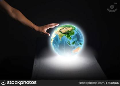 Earth planet. Close up of human hand touching Earth planet. Elements of this image are furnished by NASA