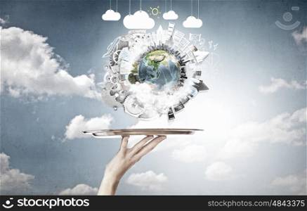 Earth planet on metal tray. Hand of waiter holding tray with Earth planet. Elements of this image are furnished by NASA
