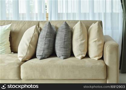 Earth tone pillows setting on light brown sofa in the living room