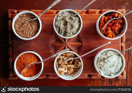 East African cuisine assorted authentic dipping sauce and spicy condiment in white cups top view food shot on wooden tray