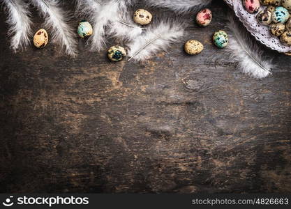 Easter background with colored eggs, feathers and basket, top view, border