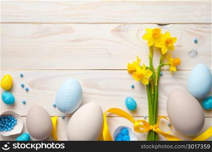 Easter background with easter eggs and spring flowers. Top view with copy space
