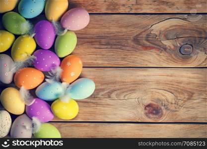 Easter background with Easter eggs on wooden table. Top view. Copy space
