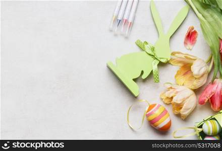 Easter background with fresh tulips, decor eggs and bunny, top view, place for text, border