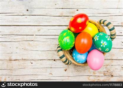 Easter background with handmade colored eggs on nest. Top view and copy space. Festive tradition