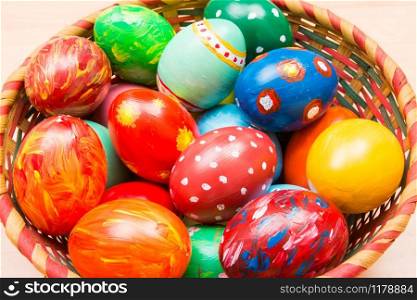 Easter background with handmade colored eggs on nest. Top view. Festive tradition
