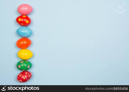 Easter background with handmade colored eggs on wooden a bright blue background. Frame and copy space. 