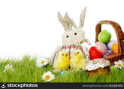 Easter basket with eggs and rabbits on green meadow with flowers