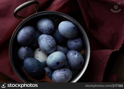 easter blue eggs in a copper pan with burgundy apron. Eggs in pan