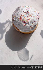 Easter cake in the style of a flat lay. Top view with shadow. Traditional food for Easter holiday in Russia. On a white background, shadows and silhouettes. Vertical.