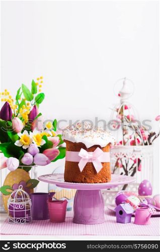 Easter cake on the cake stand and flowers, lilac desorations on the foreground with copy space
