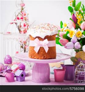 Easter cake on the cake stand and flowers, lilac desorations on the foreground