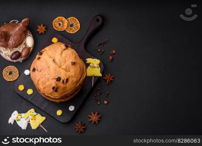 Easter cake or panettone with raisins and candied fruits on a dark concrete background