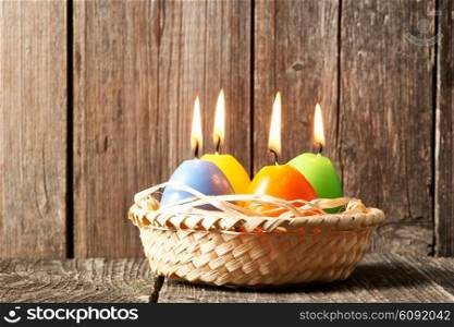 Easter candles in egg form on old wooden table