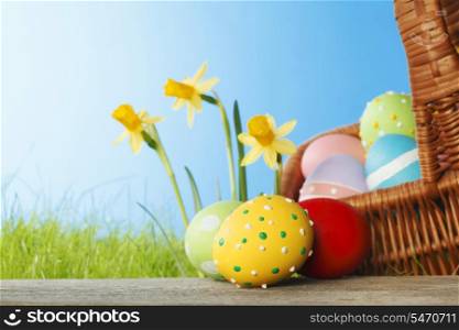 Easter card with color eggs, green grass and flowers