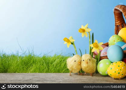 Easter card with eggs in basket, chicks and flowers