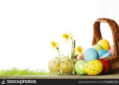 Easter card with eggs in basket, chicks and flowers