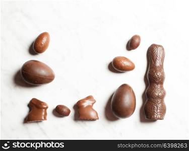 Easter chocolate bunnies and eggs spread out on white background. Delicious Easter chocolate