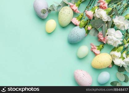 Easter colored eggs and a bouquet of white and pink carnations with eucalyptus branches on a soft green background. Festive background.