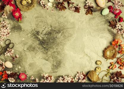 Easter composition: branch with cherry blooming flowers and easter decorations on aged stone background