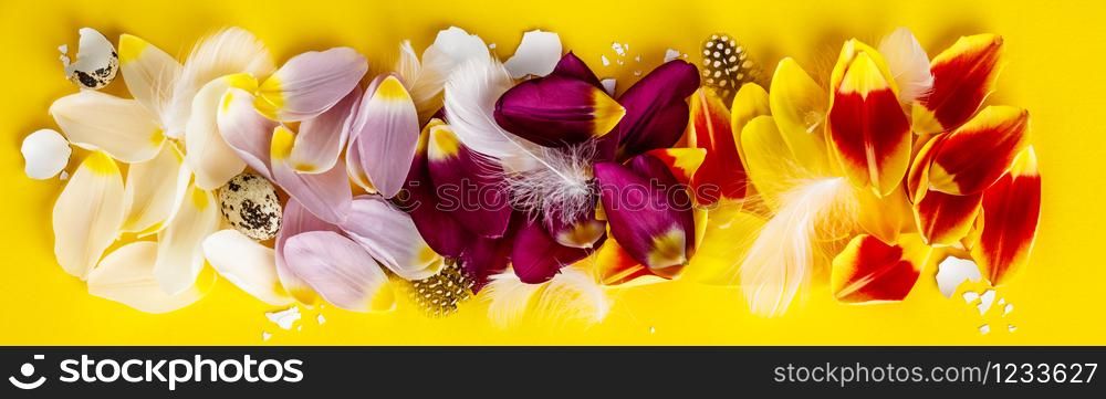 Easter composition with colorful tulip petald, feather and egg shells, flat lay