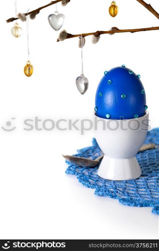 Easter composition with egg and ament on crocheted doily on white background. Egg painted and hand decorated &#xA;