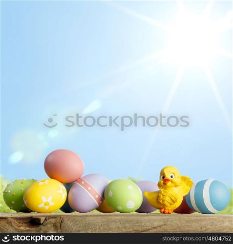 Easter composition with eggs and chicks on green meadow