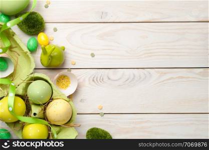 Easter composition with eggs on light wooden background. Copy space. Top view