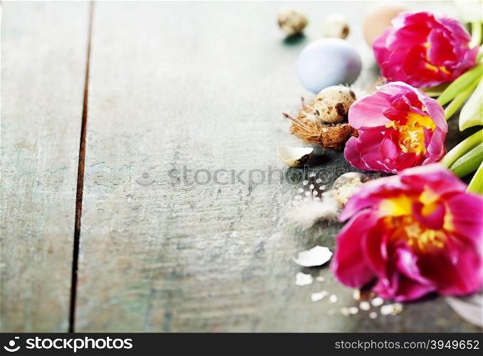 Easter composition with tulips, colorful eggs and nest