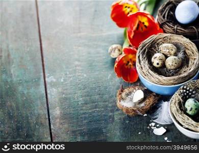 Easter composition with tulips, colorful eggs and nests