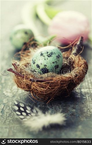 Easter composition with tulips, eggs and nest on vintage wooden background
