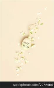Easter composition with wooden easter egg on beige background with flowers, flat lay. Happy easter concept