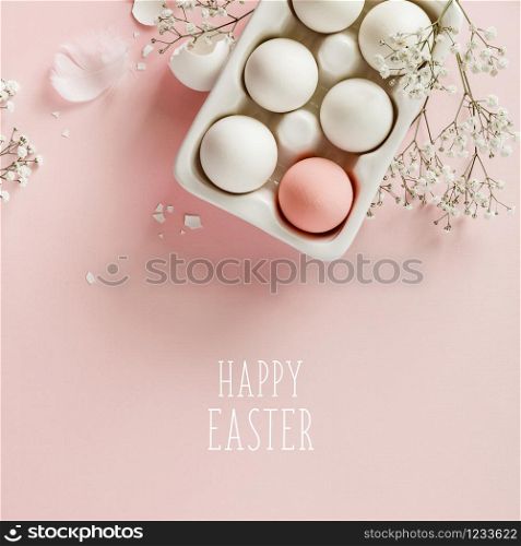Easter concept. Eggs in white ceramic holder and flowers on pink background, flat lay, copy space. Easter eggs in white ceramic holder and flowers on pink background