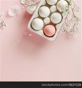 Easter concept. Eggs in white ceramic holder and flowers on pink background, flat lay, copy space. Easter eggs in white ceramic holder and flowers on pink background