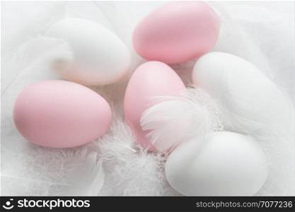 Easter concept: pink and white easter eggs among fluffy fuzzes