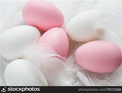 Easter concept: pink and white easter eggs among white fluffy fuzzes