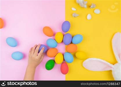 Easter day little Bunny rabbit ear with child hand and decorated eggs