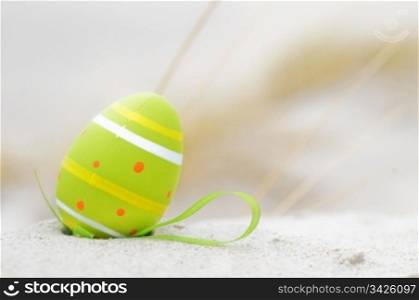 Easter decorated egg on sand. Beach in the background