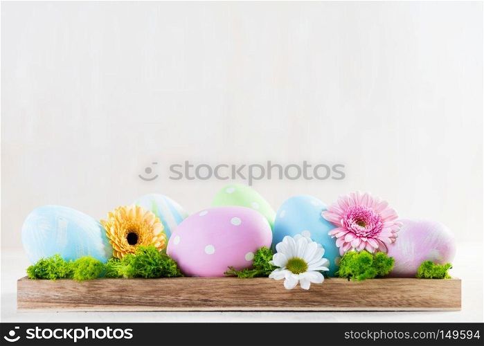 Easter decoration - eggs and flowers on a wood. White copyspace. Easter decoration - eggs and flowers on a wood